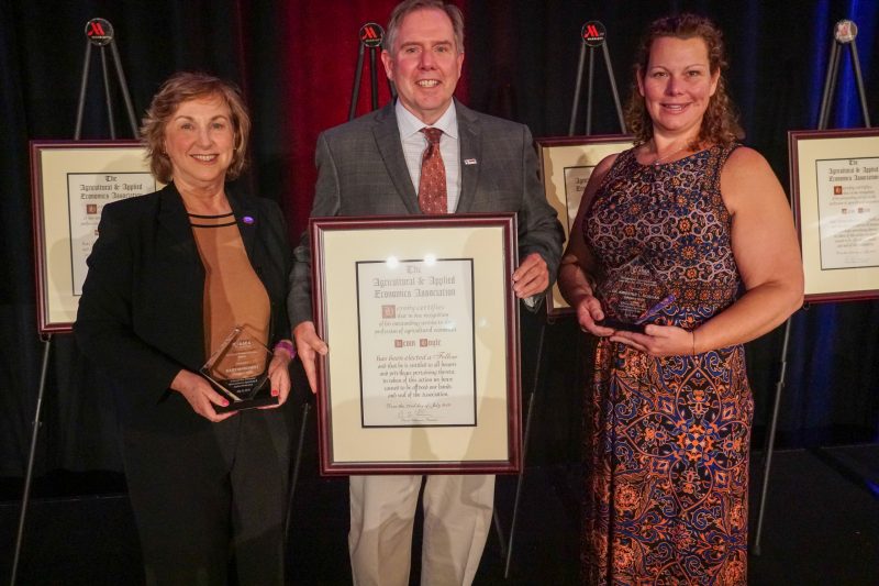 Kevin Boyle stands holding his AAEA fellow award with other award winners Mary Marchant, left, and Kimberly Morgan, right.